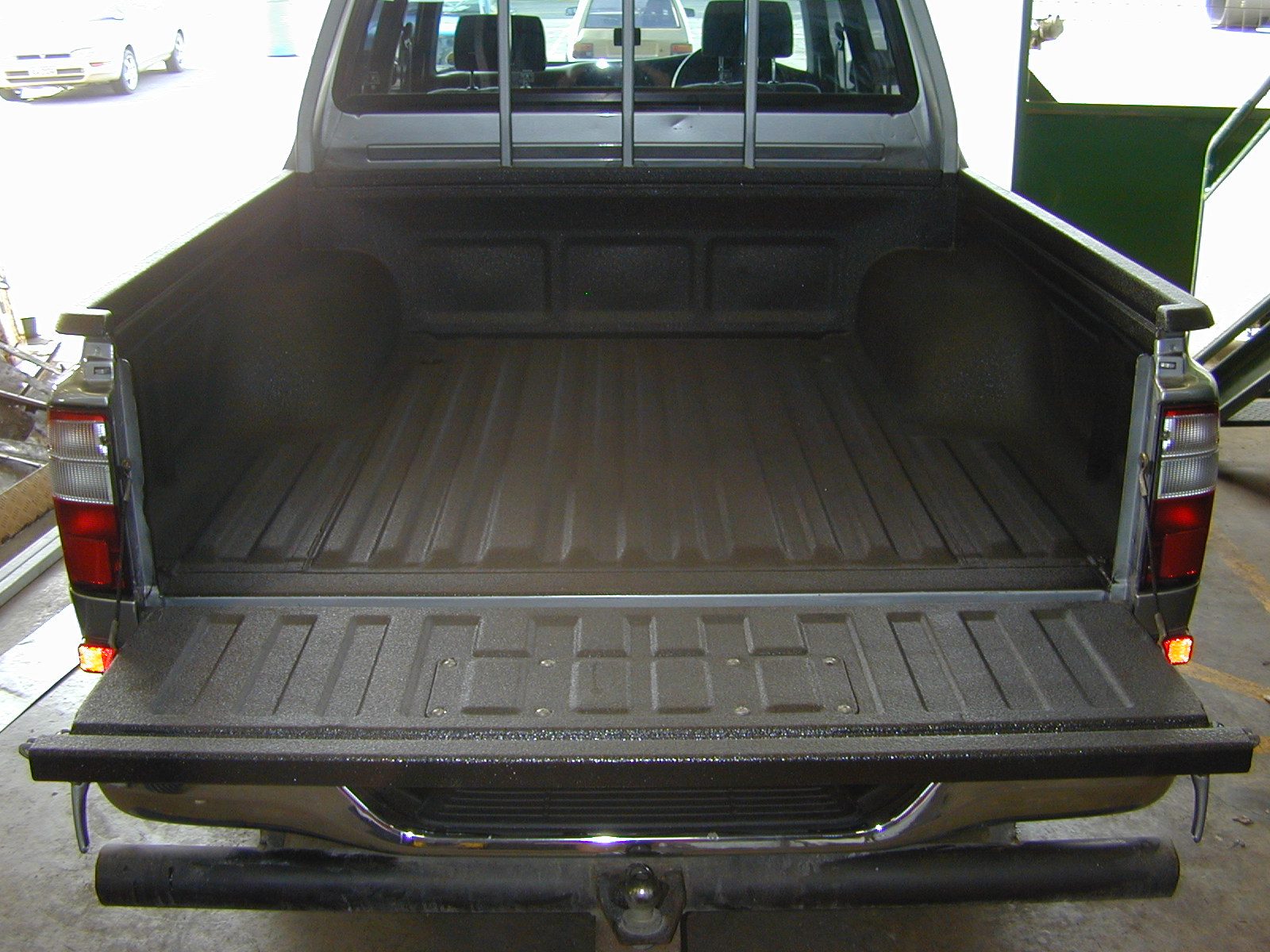 Truck bed and frame protected with a layered polyurea coating system